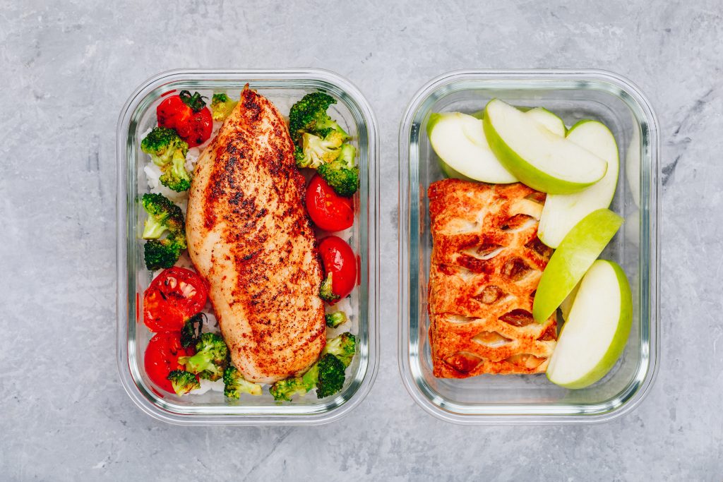 Grilled chicken meal prep containers with rice, broccoli and tomatoes and dessert pie with green apple.