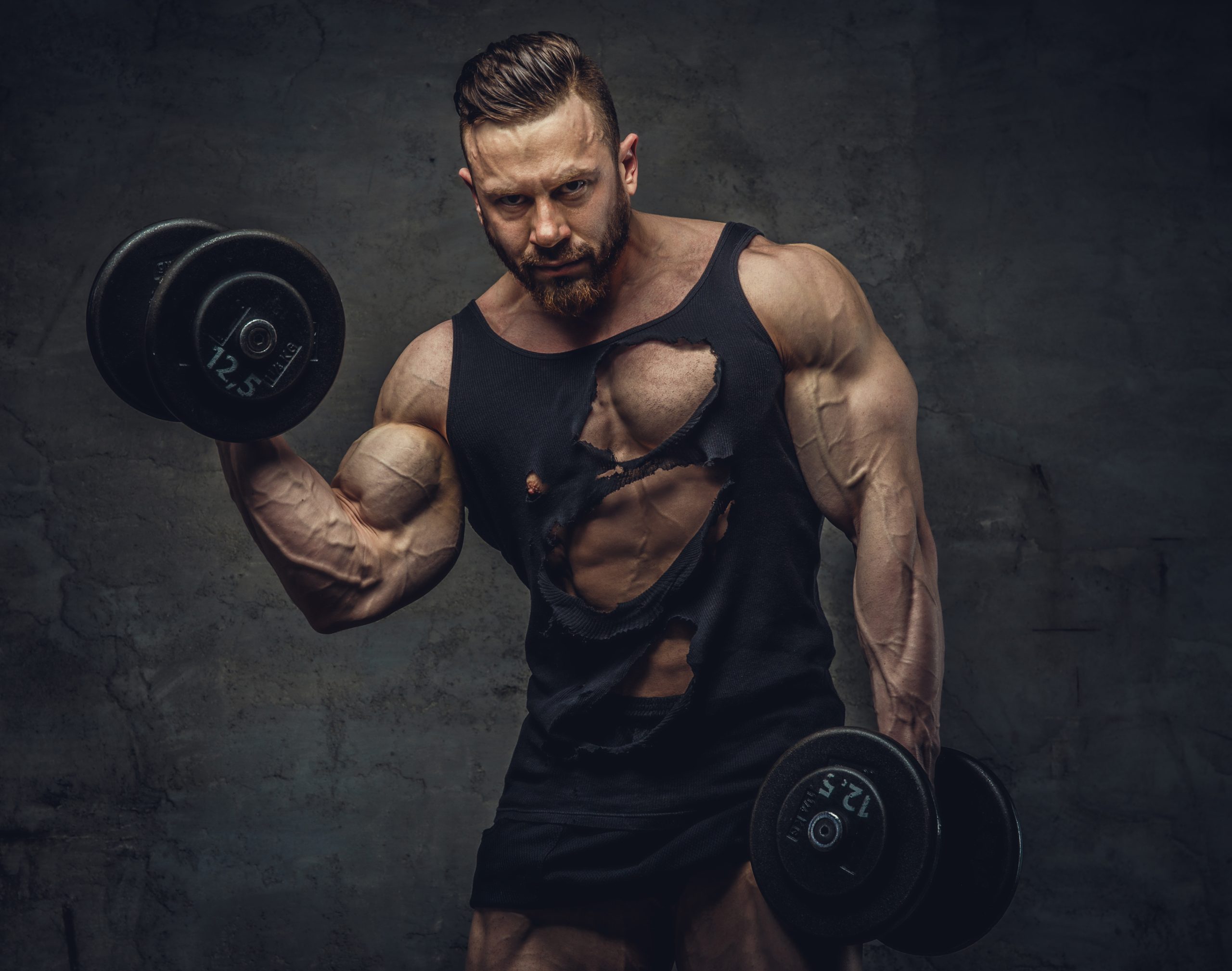 Portrait of bodybuilder with dumbbells in his arms